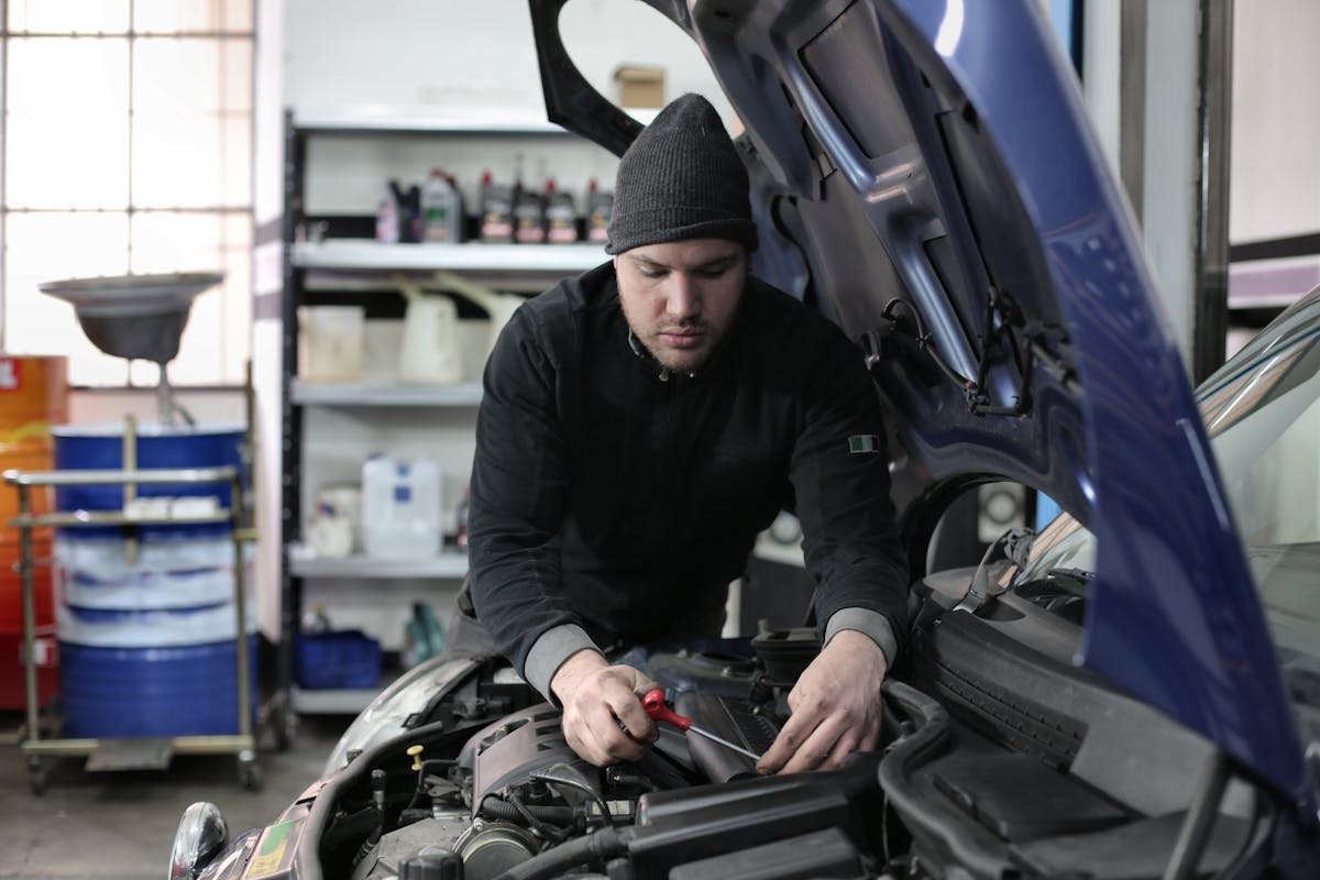 Mechanic rotating car tyres during routine maintenance